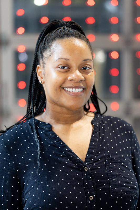 Kiarra Gibbs smiling in a black and white polka-dot shirt
